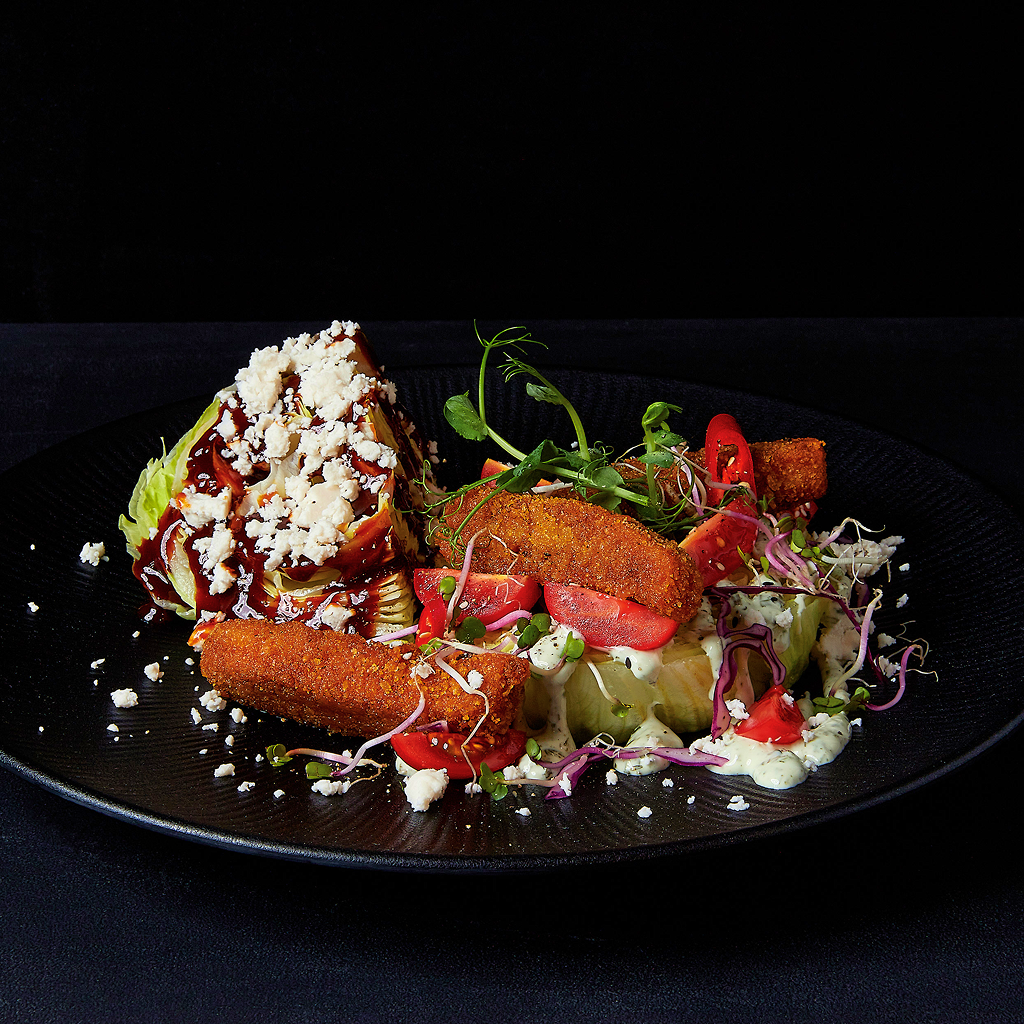 Frisch angerichteter Iceberg Ahead Salat mit knackigem Eisbergsalat, frischen Toppings und aromatischem Dressing in einer Salatschüssel serviert.